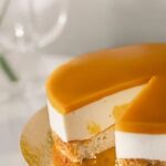 Half decorated cake with colorful frosting and sprinkles on a white background