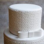 Cupcake with colorful decorations, including sprinkles, frosting, and edible pearls