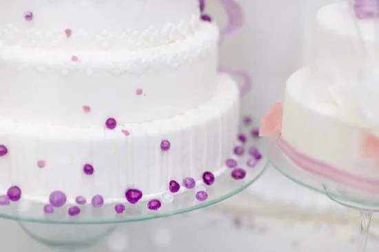 Close-up of a cake decorating pungent tool creating intricate designs on a fondant-covered cake