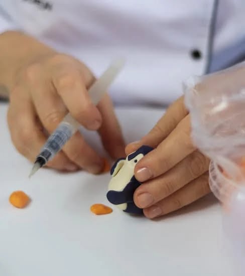 Sculpted and elegantly decorated square cakes showcasing artistic craftsmanship