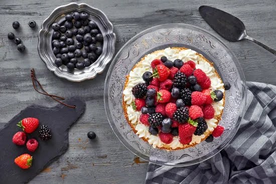 Decorated sheet cake topped with fresh strawberries and whipped cream for a delicious finish