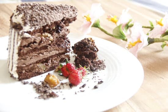 Raspberry-topped cake with decorative swirls and fresh berries, a step-by-step guide on how to decorate a cake with raspberries