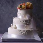 Vibrant sunflower cake decoration with yellow petals and green leaves for a summer-themed celebration